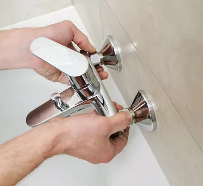 Technician replacing a worn faucet in Tempe