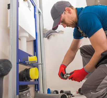 Plumber servicing residential plumbing in a Tempe home