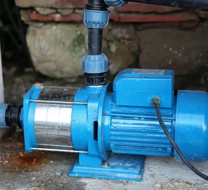 Technician installing a sump pump in a Tempe home