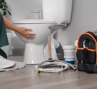 Plumber repairing a toilet in a Tempe home